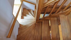 Una escalera de caracol con barandillas de madera y vistas del piso superior.