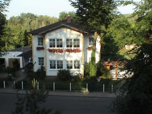 A two-story building with a symmetrical facade, large windows, and flower boxes on the second floor.
