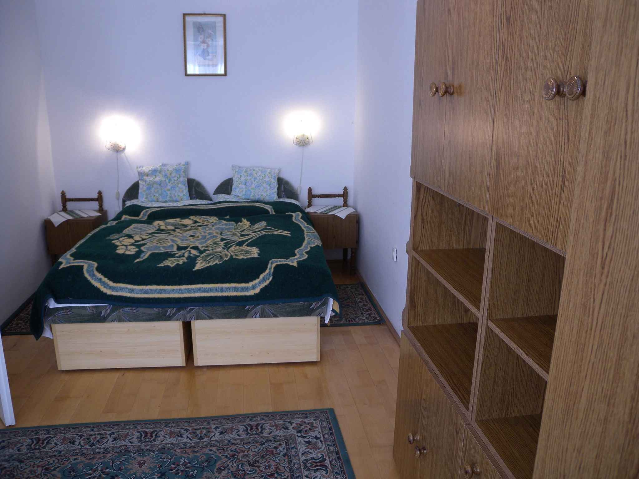 A bedroom with a bed, bedside tables, a wardrobe, and a rug.