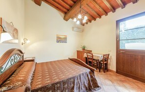 A bedroom with a bed, a desk, and a chair. There is a window with a view of trees. - Amazing home in Orentano PI with outdoor swimming pool (Orentano PI)