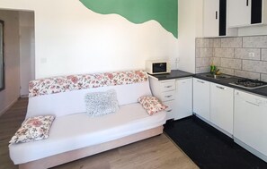 A compact living space with a sofa, a microwave, a sink, and cabinets. - 2 bedroom gorgeous apartment in Split (Split)