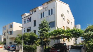 Un immeuble résidentiel à plusieurs étages, doté d’une façade plane, de nombreuses fenêtres et d’un balcon situé à l’étage supérieur.