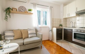 Relax in this inviting living space with a sofa, coffee table, and kitchenette.