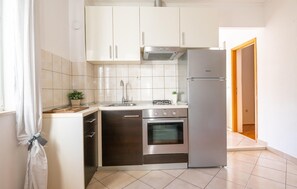 Kitchen features a sink, modern faucet, range hood, and stainless steel oven.