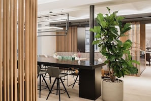 A modern dining area with a black table, chairs, and a potted plant. - Single Classic - Hotel Goldenes Schiff (Bad Ischl)