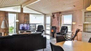 Una sala de estar acogedora con chimenea, asientos cómodos y televisor.