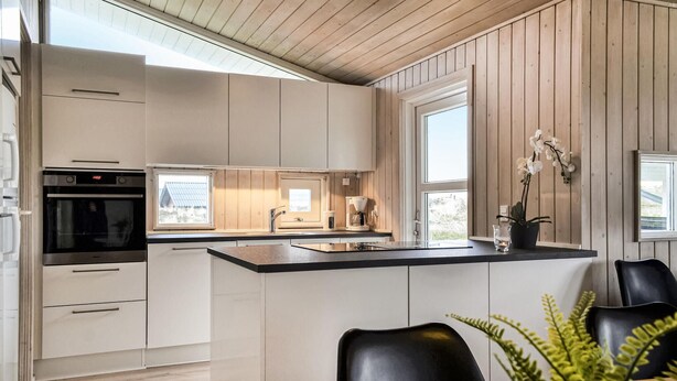 Una cocina moderna con una isla central, horno integrado y cafetera.