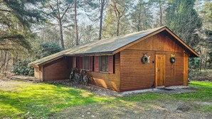 A small wooden cabin with a sloped roof, a porch, and a door with a number plate. - Cozy home in Neede with sauna (Neede)
