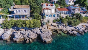 Eine Küstenstadt mit Steinhäusern, klarem türkisfarbenem Wasser und felsigen Klippen.