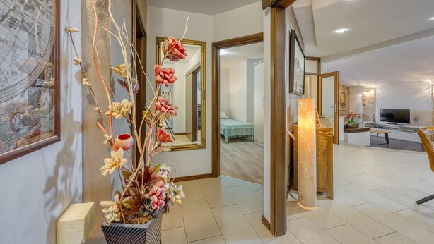 A modern hotel lobby with a large mirror, a decorative plant, and a television in the background. - Cozy apartment in Kanfanar (Kanfanar)