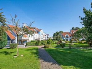 Un quartiere residenziale con case, un vialetto lastricato e prati curati.