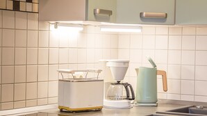 A kitchen with a modern stove, a coffee maker, and a kettle on the counter. - Wohnpark An der Muehle Whg Cuba1-1 .. - Cuba 1. 1 (Kühlungsborn)