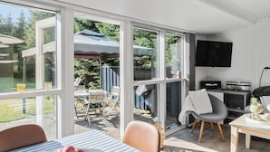 A modern living room with a large sliding glass door leading to an outdoor patio area. - Pet friendly home in Væggerløse with sauna (Væggerløse)