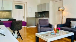 A modern apartment with a dining area, kitchen, and living room.