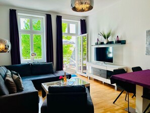 Un salon moderne comprenant un canapé, une table basse, un téléviseur et un coin repas.
