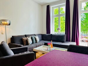 Ein modernes Wohnzimmer mit einer Couch, einem Couchtisch und Blick auf Grünfläche.