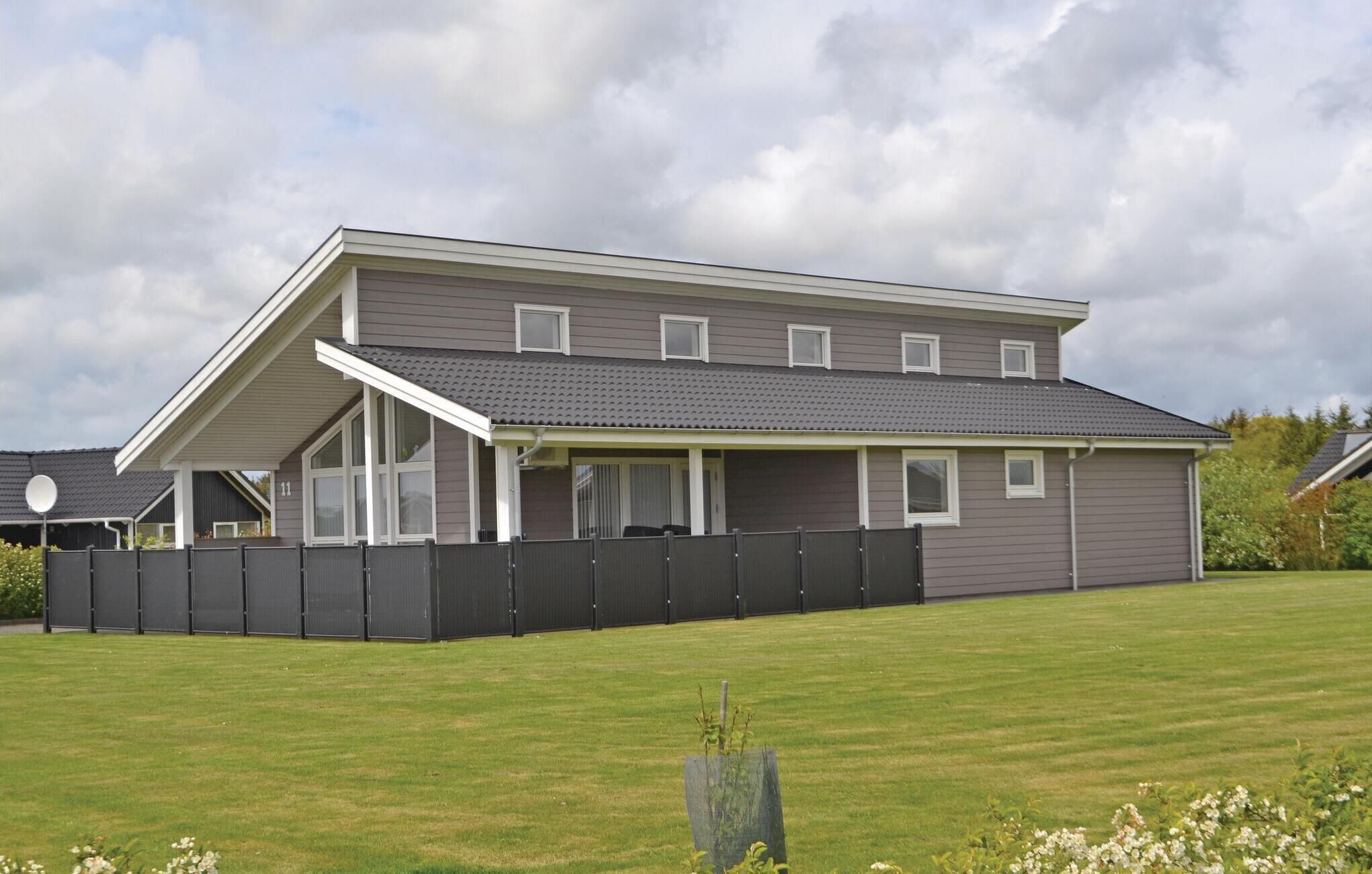A two-story house with a sloped roof, a covered porch, and a fenced yard.