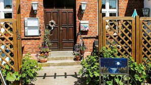 A brick building with a sign reading "Gasthof Rankwitzer Hof" and a wooden gate with a sign of a moonlit night scene. - Double room 1 - Rankwitzer Hof (Rankwitz)