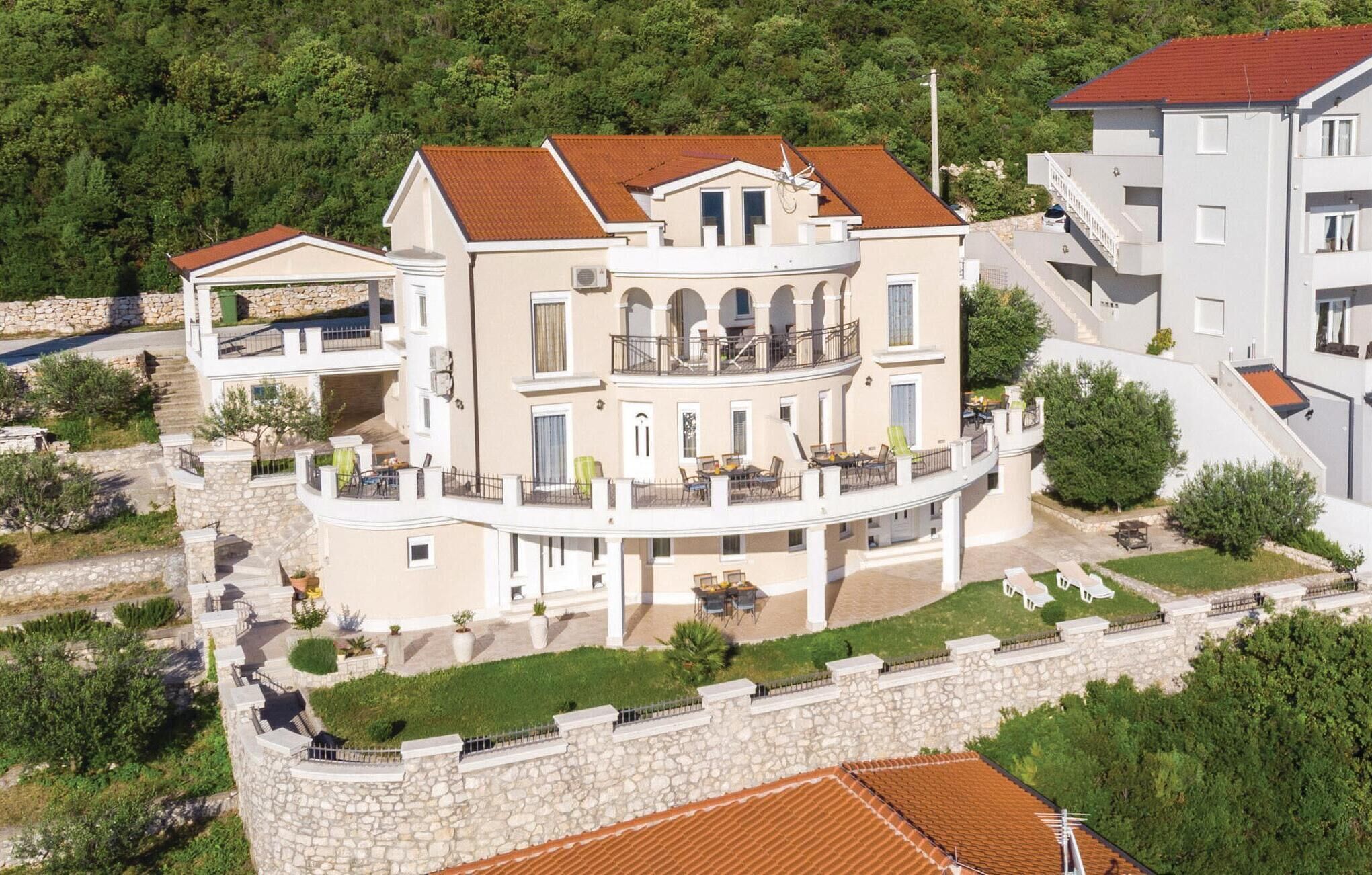 Un grand immeuble à plusieurs étages, doté d’une cour intérieure, de balcons et d’un mur de pierre qui entoure la propriété.
