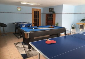 A pool table with a blue felt surface, a foosball table, and a billiards table in a room with blue walls and a patterned border. - Apartment 4 Marguerite - House Jasmine (Sankt Andreasberg)