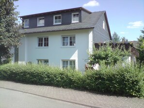 A two-story building with multiple windows, a garage, and a paved driveway.