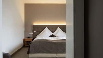 Un dormitorio con cama, mesita de noche, lámpara y una lámpara de pared.