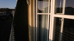 A building with a large window, a visible door, and a small outdoor area with a fence. - Apartment Albatros - Holiday home Goethestraße, Apartment Albatros (Apt. 18) (Heringsdorf)