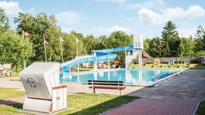 Uima-allas, jossa on vesiliukumäki, penkki ja pelastustorni.