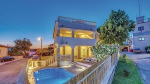 Un immeuble de deux étages doté d’un balcon, d’une piscine et d’un jardin bien entretenu.