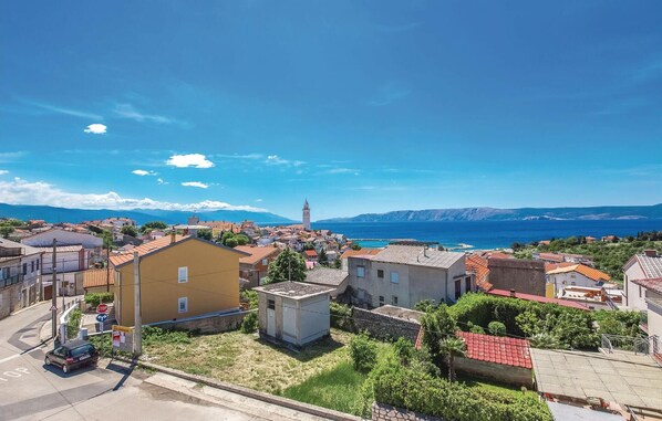 A coastal town with buildings, a prominent tower, and a clear view of the sea.