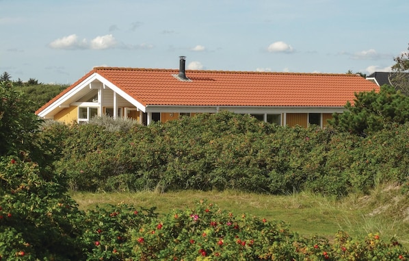 Standalone cottage surrounded by lush gardens.