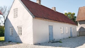 A small, single-story building with a red-tiled roof and white walls.