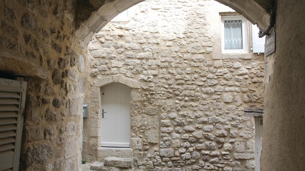 A narrow stone corridor with a white door and a window with a lace curtain. - Cozy home in Reillanne with WiFi (Reillanne)
