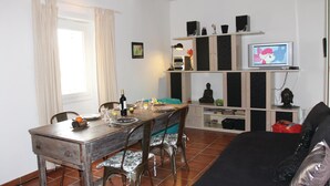 A dining area with a wooden table and chairs, a television on a shelf, and a Buddha statue. - Cozy home in Reillanne with WiFi (Reillanne)