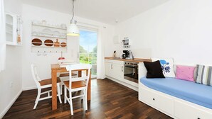Cocina compacta con comedor, un banco integrado y ventana con vistas a zonas verdes.