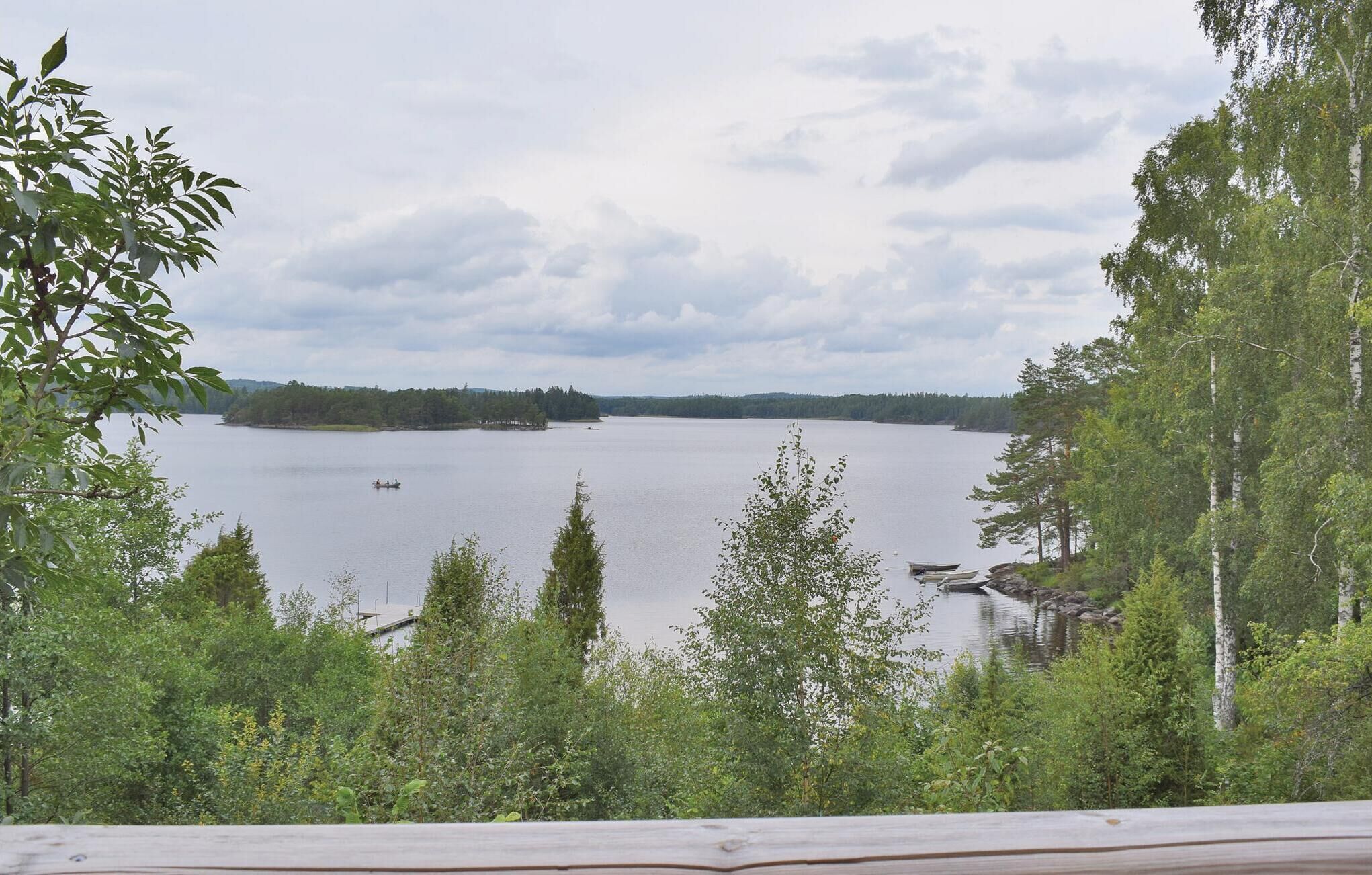 A lake surrounded by dense forest and a wooden deck.