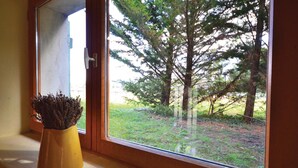 A window with a view of a forested area and a yellow vase with dried plants on the windowsill. - Cozy home in Valreas with WiFi (Valreas)