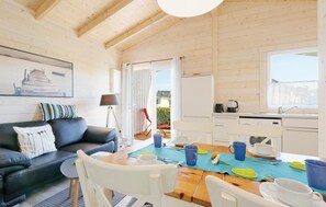 Un intérieur de chalet chaleureux comprenant un espace de vie, un coin repas et une petite cuisine.
