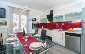Enjoy meals and entertainment in this well-equipped kitchen and dining area, featuring a dishwasher, oven, and microwave, perfect for dining out or hosting guests.