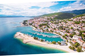 A coastal town with a marina, residential buildings, and a beach.