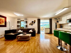 Un salon moderne avec un canapé, une table basse et des tabourets de bar verts.