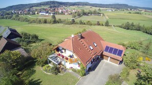 Il s’agit d’une propriété résidentielle dotée d’un toit en pente, de panneaux solaires et d’un jardin fleuri.
