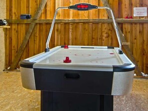 Un jeu de hockey sur table doté d’un tableau de bord numérique, d’un cadre en métal et d’un panneau arrière en bois.