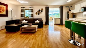 Ein modernes Wohnzimmer mit einer Couch, einem Couchtisch und grünen Barhocker.