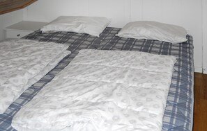 A bed with a plaid bedspread and white pillows. - Gorgeous home in Vågstranda with house sea view (Vågstranda)