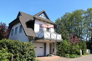 A two-story house with a balcony, a garage, and a red umbrella. - Holiday house Wölkchen - holiday house (Zinnowitz)