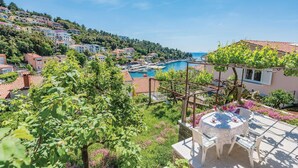 A coastal town with terraced houses, a marina, and a table with chairs on a balcony. - 1 bedroom gorgeous apartment in Rabac (Rabac)