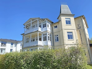 A multi-story building with balconies and a prominent tower.