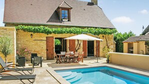 A house with a swimming pool, a patio with outdoor furniture, and a stone wall. - Beautiful home in St Amand de Coly (St Amand de Coly)