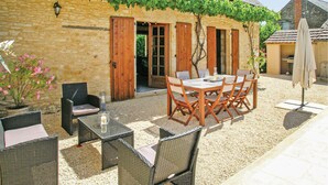 A stone building with a covered patio, outdoor seating, and a pergola with vines. - Beautiful home in St Amand de Coly (St Amand de Coly)